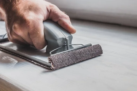 Hand schleift Holz mit Schleifklotz